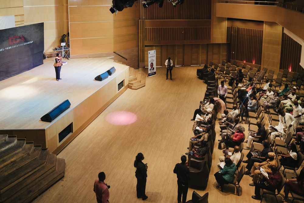 The auditorium from the stage, showing raked seating, timber wall panelling and the front-of-house lighting positions.
