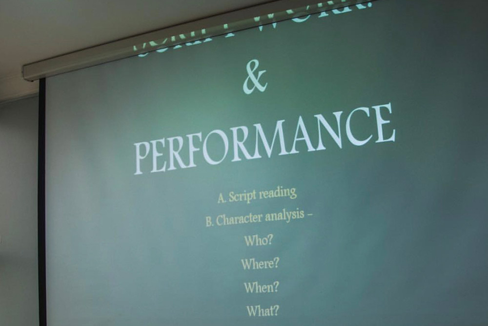 A projected class slide breaking down script reading and character analysis — who, where, when, what.